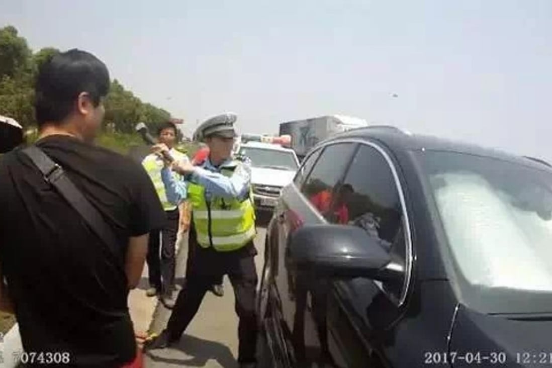 A police officer smashes his way into the car. Photo: Handout