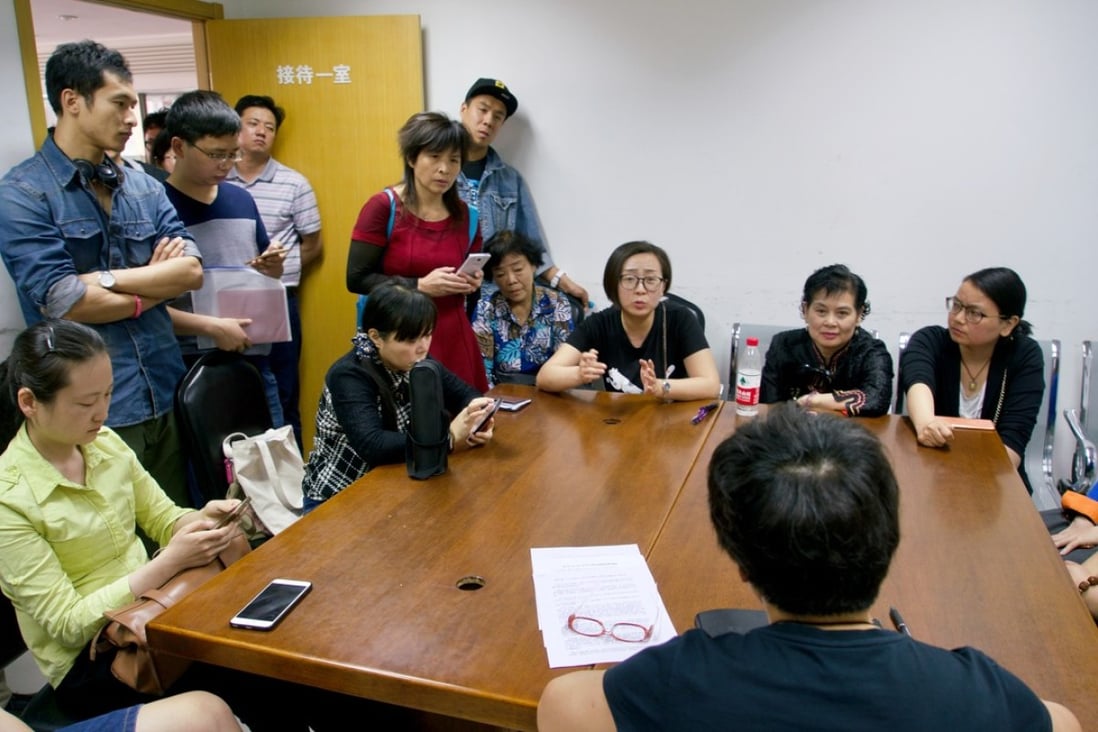 An official from the Beijing Municipal Commission of Housing and Urban-rural Development talks with protesting apartment buyers on Wednesday. Photo: Tom Wang