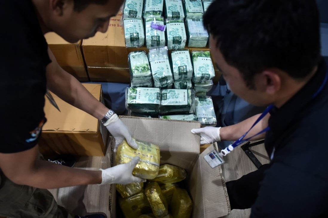 Thai narcotics police putting away yellow packages of Ice and ketamine hidden in green tea bags. Photo: AFP