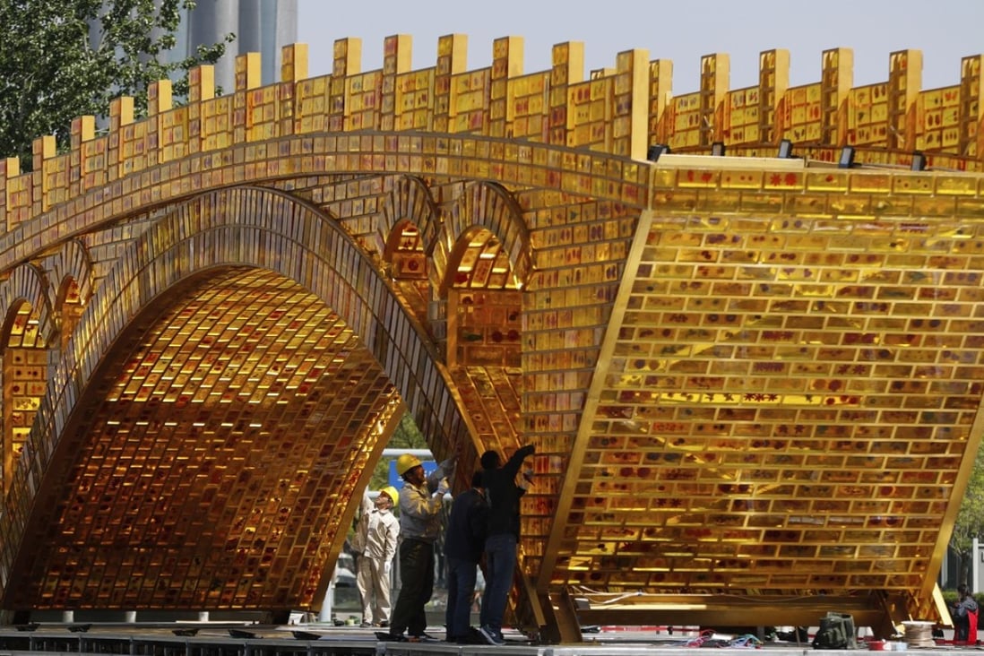 Workers install a ‘Golden Bridge of Silk Road’ on a platform outside the National Convention Centre in Beijing, the venue which hosted the Belt and Road Forum for International Cooperation last month. Photo: AP