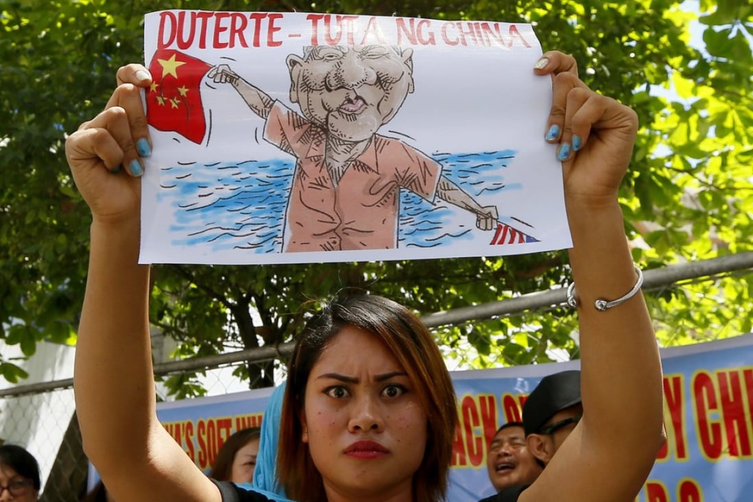 A protester displays an caricature of Philippine President Rodrigo Duterte waving a Chinese flag during a protest in front of the Chinese consulate in Makati, Manila, in March against China's militarisation of disputed islands in the South China Sea. Photo: AP