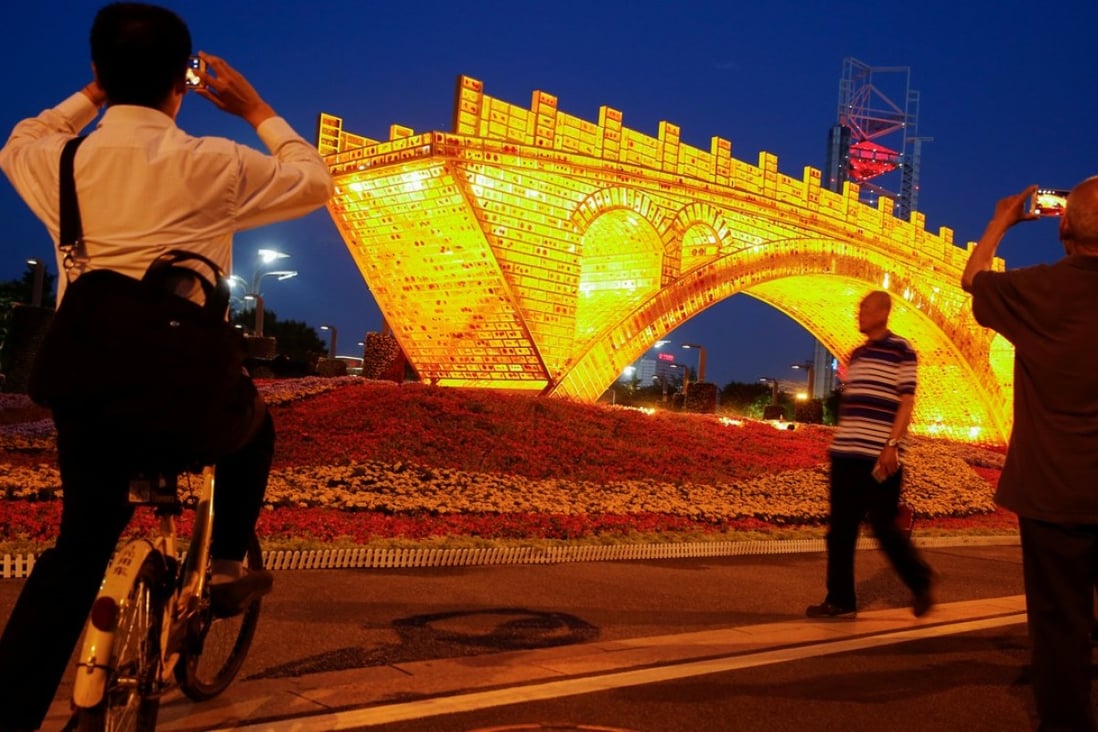 People take pictures of the “Golden Bridge on Silk Road” art installation, set up ahead of the belt and road forum in Beijing this weekend. The forum has an emphasis on mutual discussion, mutual construction and mutual sharing. This is greatly welcomed. Photo: Reuters