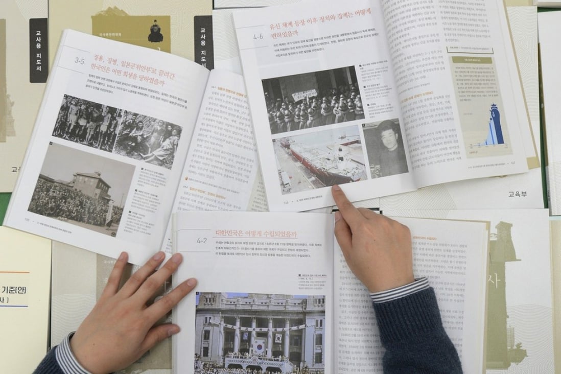 A government worker shows the final version of state-authored history textbooks President Moon is scrapping. Photo: AP
