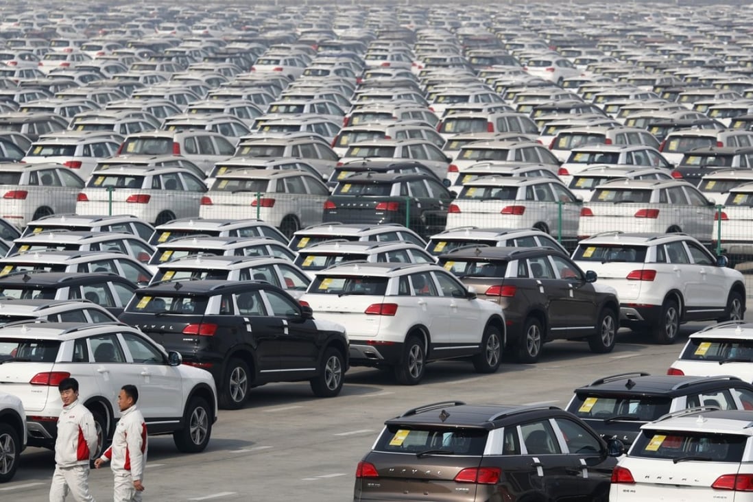 Workers walk past hundreds of Haval SUVs parked outside the Great Wall Motors assembly plant in Baoding in north China's Hebei province. Photo: AP