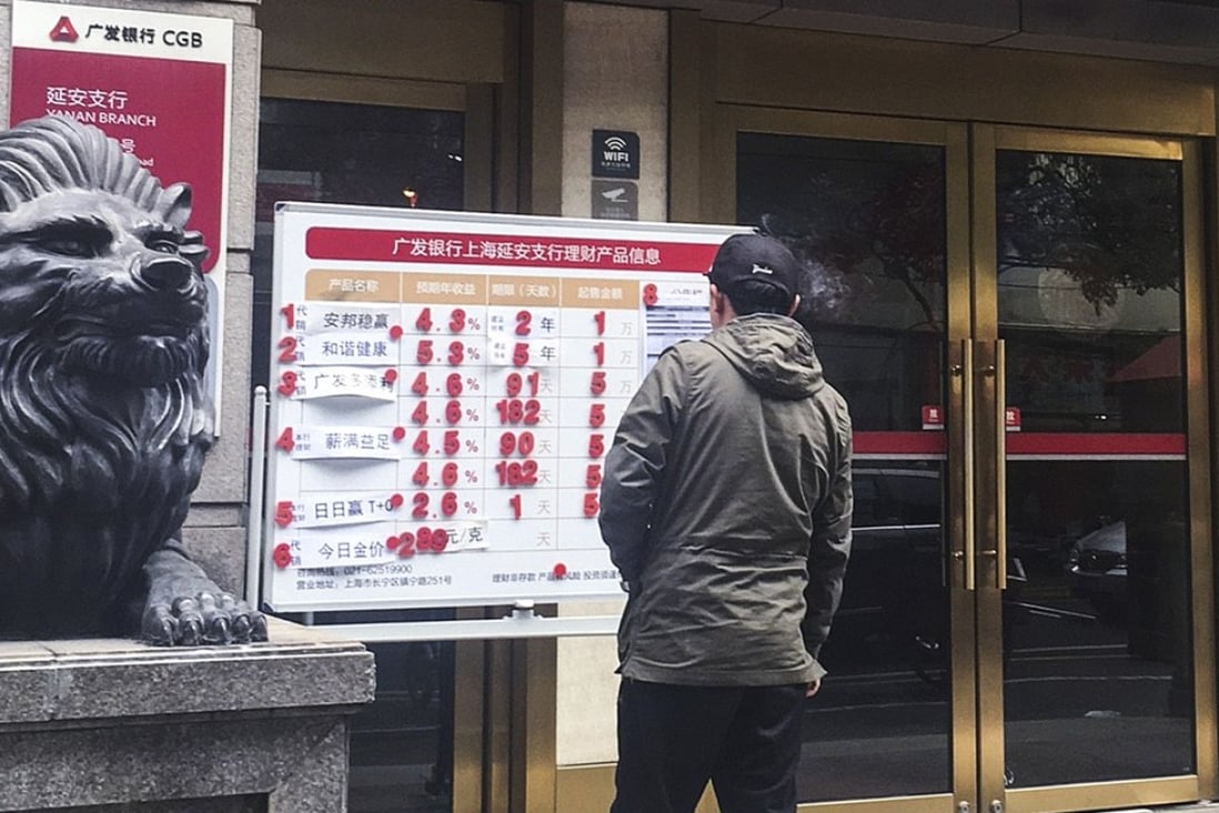 A Chinese passer-by checks out the advertisement of a universal insurance policy and other wealth management products by Anbang. The CIRC is banning insurers from selling universal life products as an add-on to regular life policies to rein in industry risks. Photo: Maggie Zhang