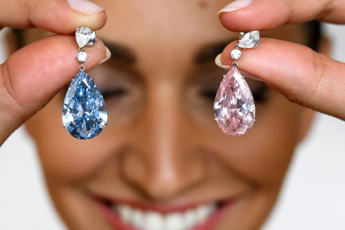A model poses with the “Apollo Blue” and “Artemis Pink” diamonds, mounted as earrings, during a press preview by Sotheby's auction house, on May 11 in Geneva. Photo: AFP