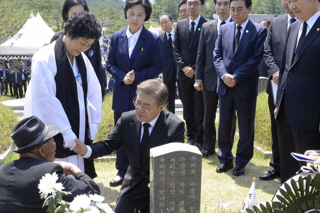 South Korean President Moon Jae-in consoles family members of the deceased in front of a grave marker during the 37th annual May 18 Democratic Uprising memorial at the Gwangju National Cemetery. Photo: AP