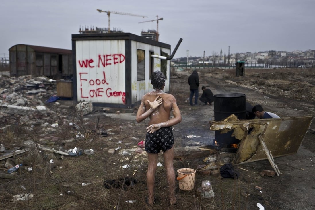 A 14-year old unaccompanied migrant from Afghanistan bathes near an old train carriage where he and other migrants took refuge in Belgrade, Serbia, in February. Photo: AP