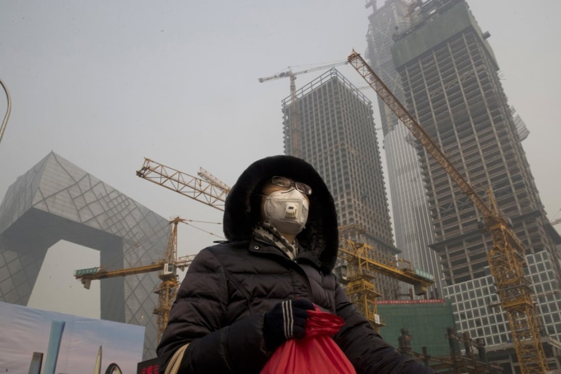 A woman wears a mask as smog continues to choke Beijing in this January file photo. Photo: AP