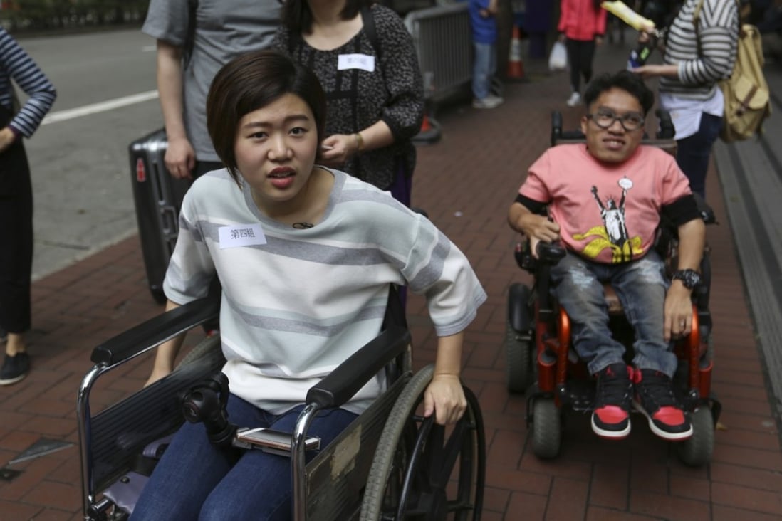 Writer Rachel Cheung and photographer Kevin Cheung try to complete the wheelchair challenge around Wan Chai. Photo: Xiaomei Chen