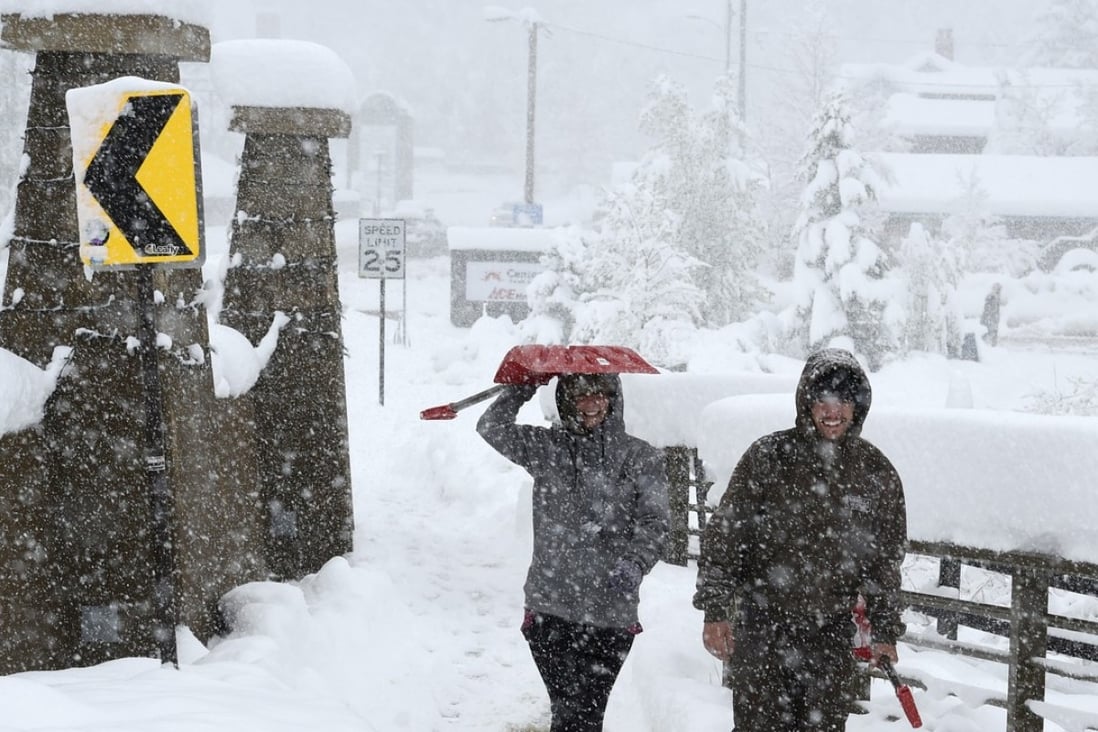 Emily Weir, left, and Barrac Elgee, head to their home for snow shovelling during a steady snow in Nederland, Colorado. A rare May snow dump up to three feet of snow across Colorado. Photo: AP