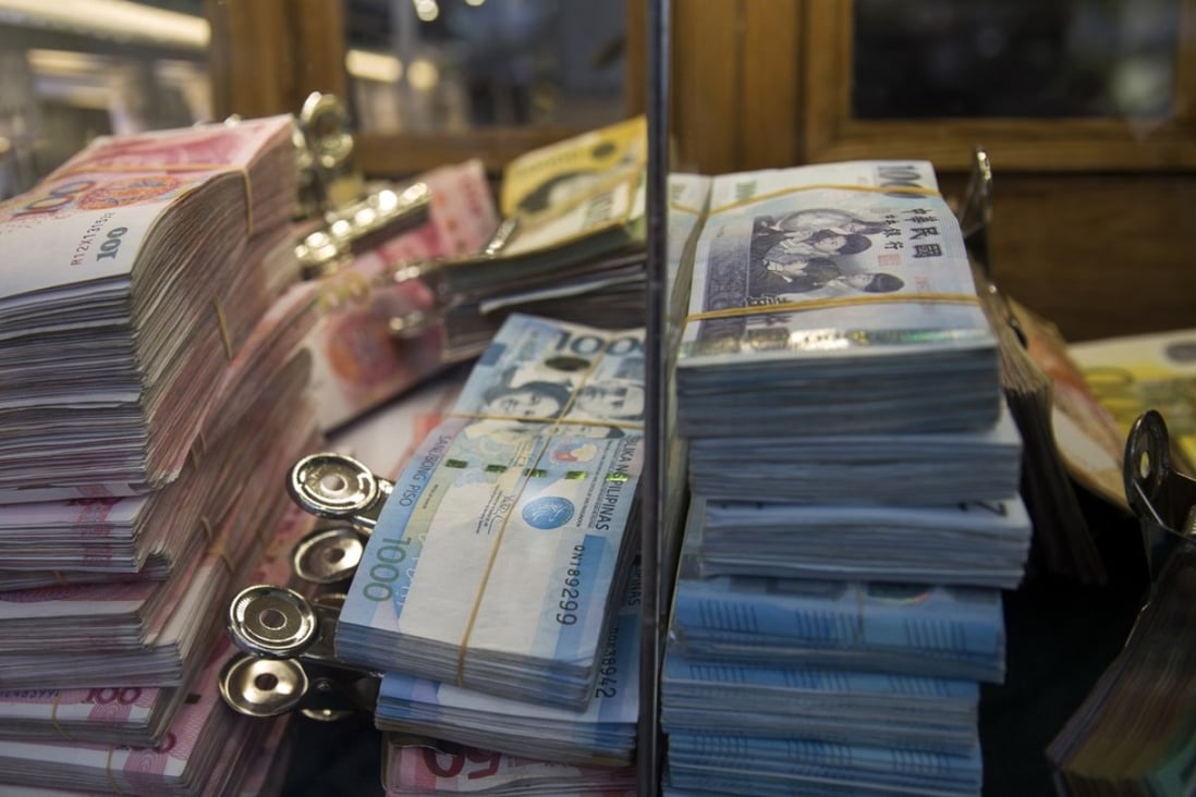 Chinese, Philippine and Australian banknotes stacked at a currency exchange store. Photo: Bloomberg