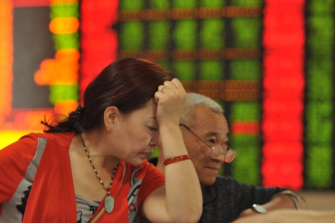 Investors check prices at a brokerage house in Fuyang in central China's Anhui province on June 16, 2015. China's benchmark index fell that day by 7.4 per cent – the biggest single-day loss in seven years. Photo: EPA