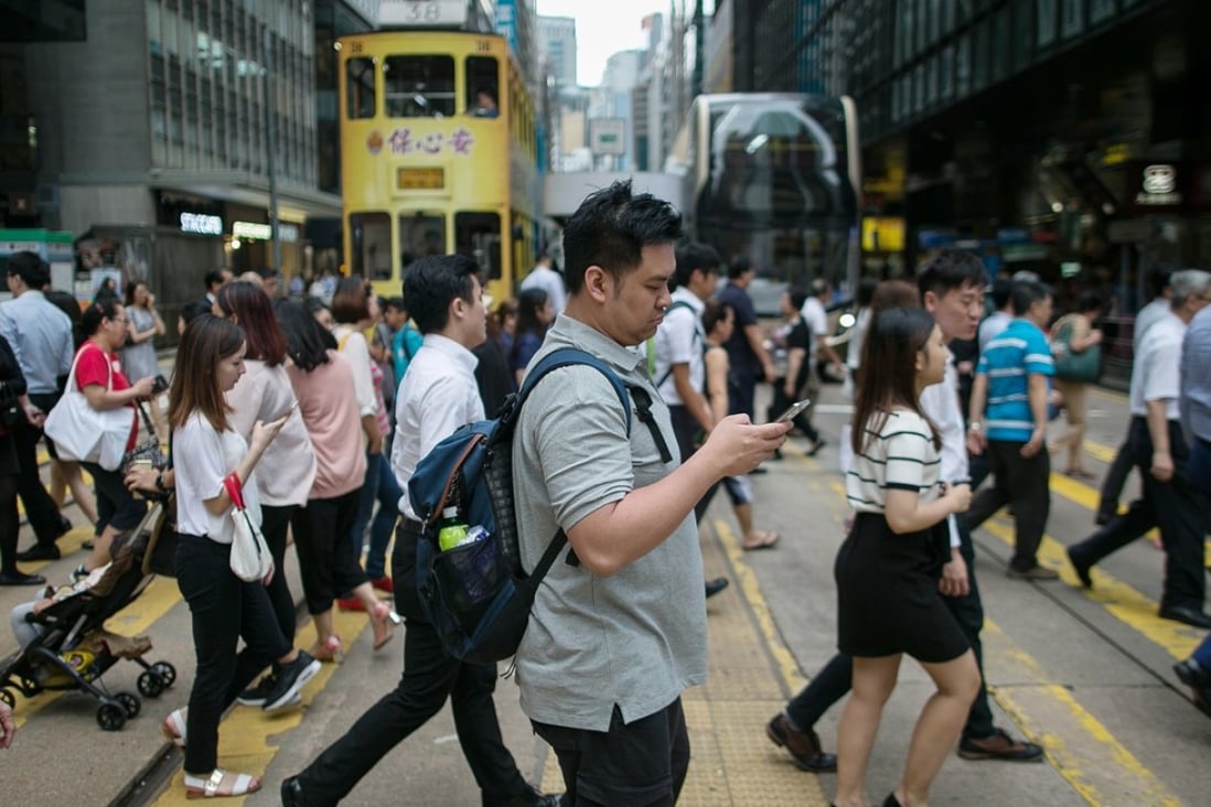 Pedestrians cross a road in Central. A survey last year found that four in 10 Hongkongers wanted to leave the city. Photo: EPA