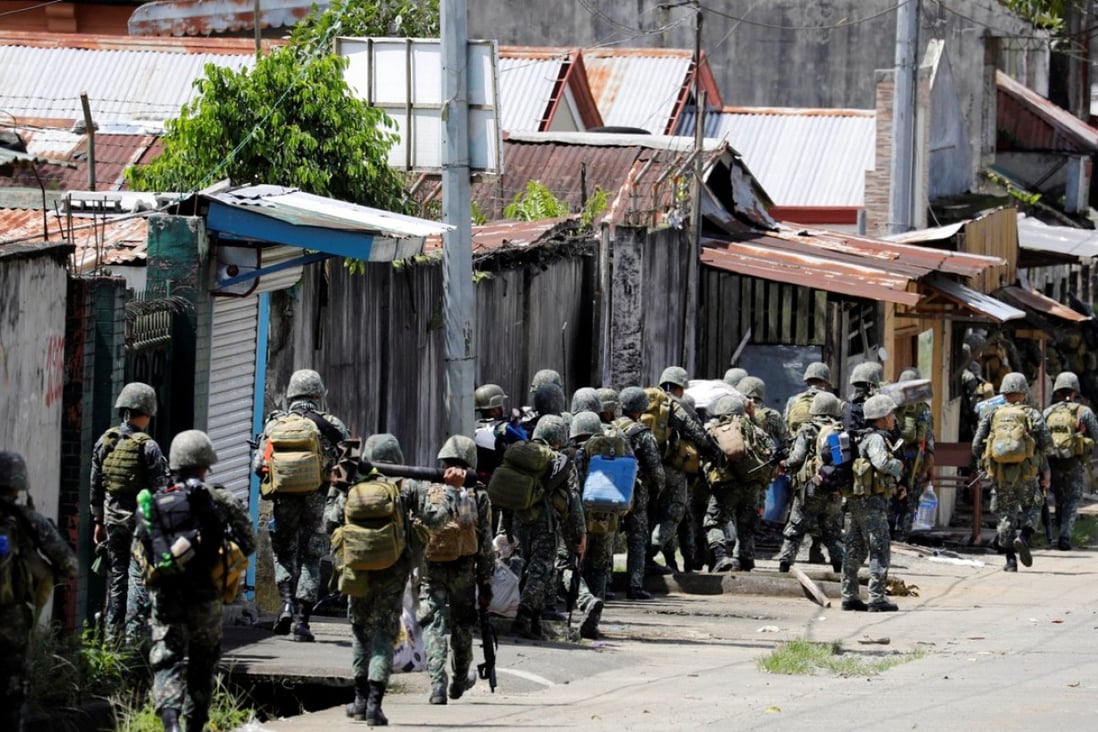 Philippine Marines advance their positions as more soldiers reinforce to fight the Maute group in Marawi City. Photo: Reuters