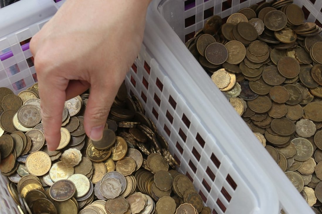 Staff at the Hong Kong Monetary Authority with baskets of old coins. Photo: May Tse