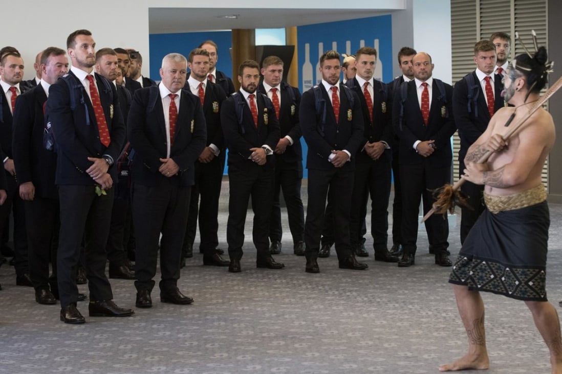 The British & Irish Lions watch as a maori warrior leads a haka on their arrival at Auckland. Photo: AP