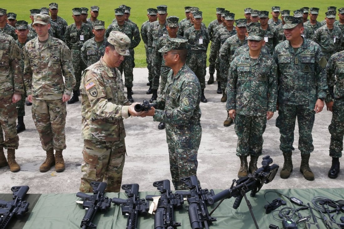 Philippine Marine Major General Emmanuel Salamat, fourth from right, receives an M4 rifle with grenade launcher from US Army Colonel Ernest Lee during turnover of brand new military weapons. Photo: AP