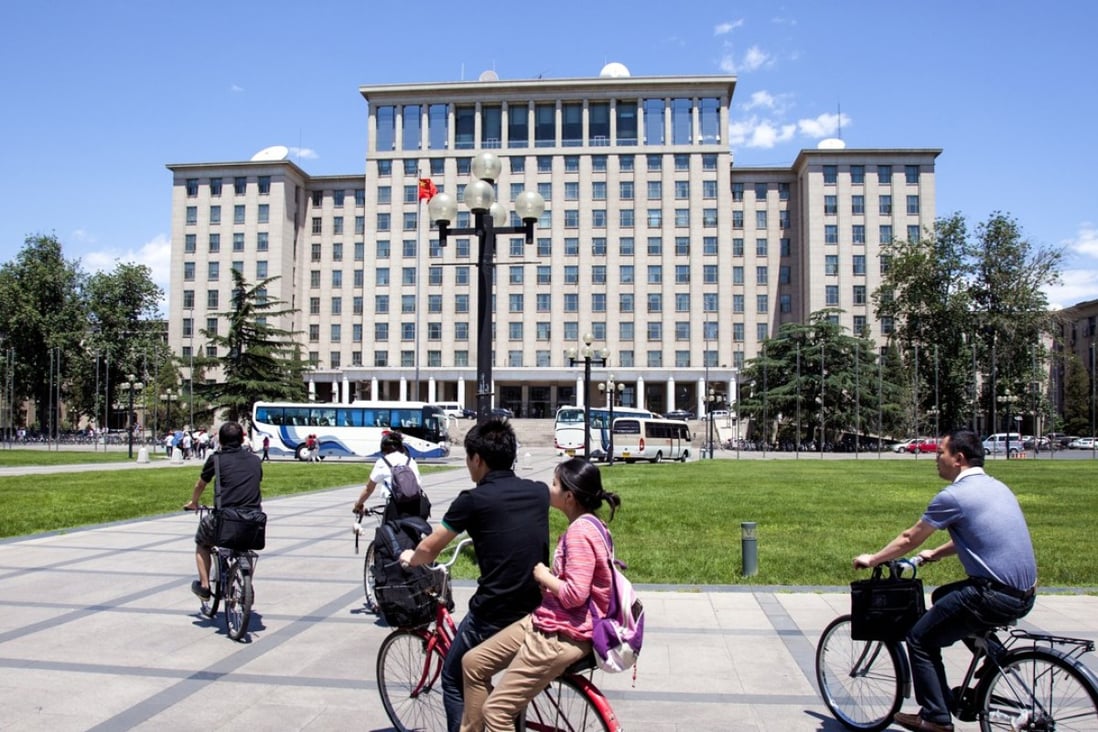 Students cycling past the central main building on campus at Tsinghua University in Beijing, China. Photo: SCMP Pictures