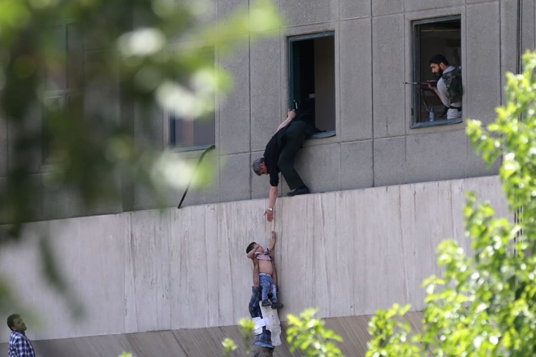 Iranian policemen evacuate a child from the parliament building in Tehran. Photo: AFP