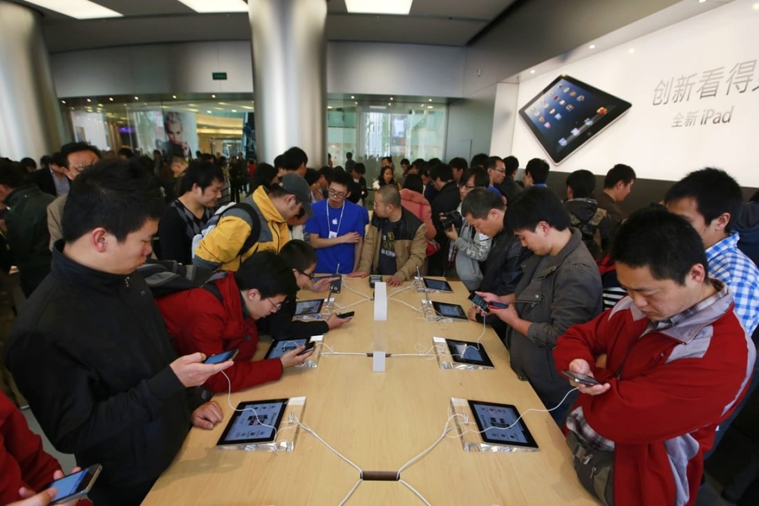 Chinese customers look at Apple products in Apple’s Wangfujing shopping district store in Beijing. Chinese authorities say they have uncovered a massive underground operation run by Apple employees selling computer and phone users’ personal data. Photo: EPA