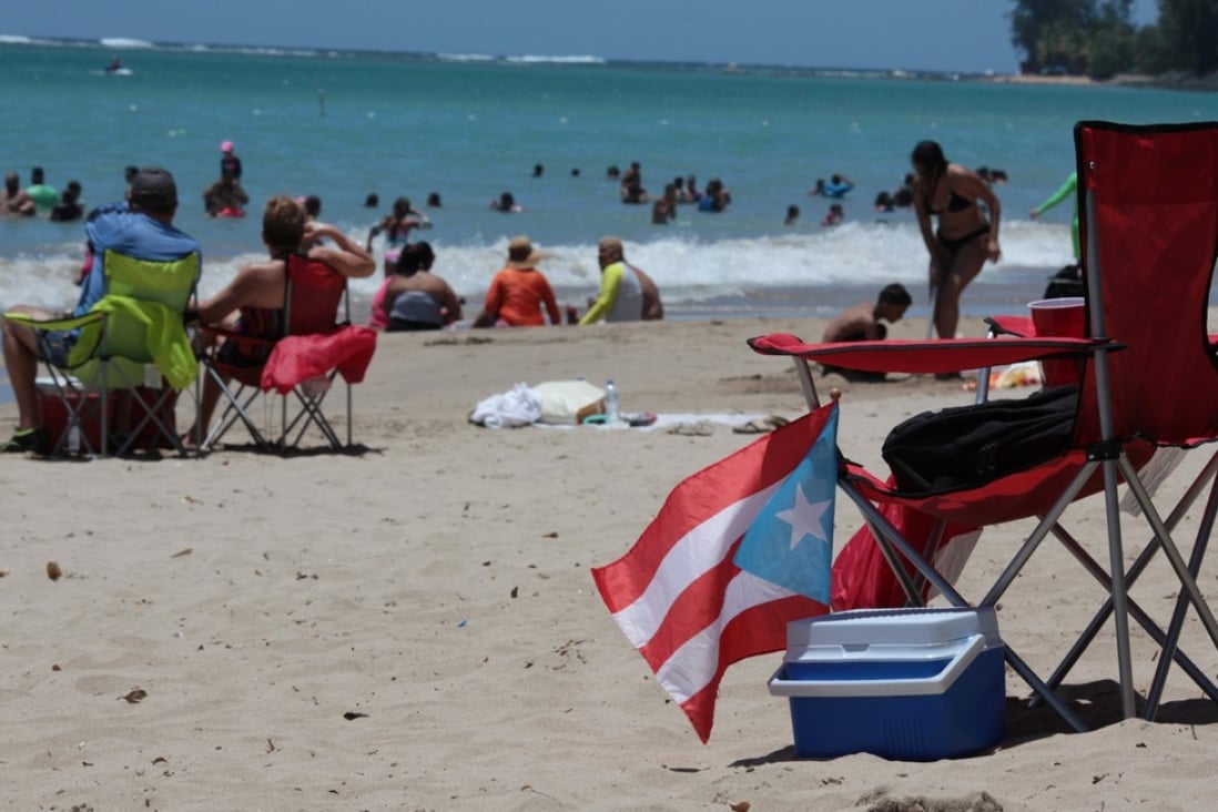 People spend time at the beach on June 11 as Puerto Ricans headed to the polls to vote in a referendum on the future of the US territory. Photo: Reuters