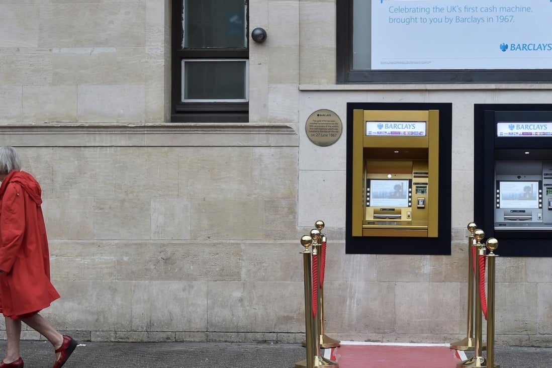 A woman walks past a golden ATM, marking the location of the first 'hole in the wall' which opened 50 years ago, in Enfield, Britain. Photo: Reuters