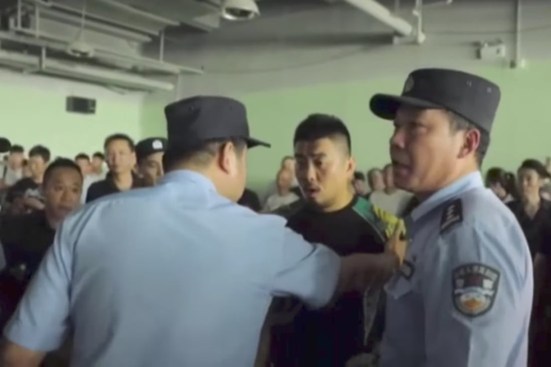 Police officers talk to Xu Xiaodong (centre), who was set to lead a team of mixed martial artists in a fight with four tai chi experts led by master Ma Baoguo on Monday in Shanghai. Photo: Handout