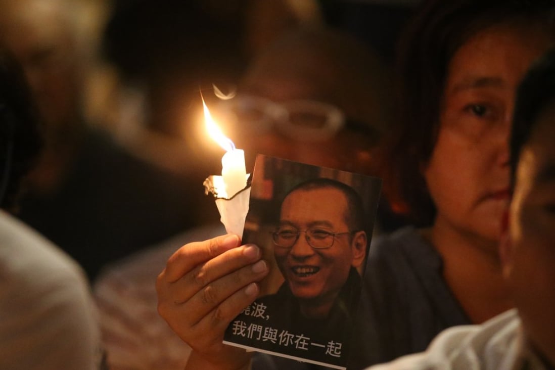 A rally participant holds a candle and photo of Liu Xiaobo at the vigil outside the Court of Final Appeal in Central in Hong Kong. Photo: K. Y. Cheng