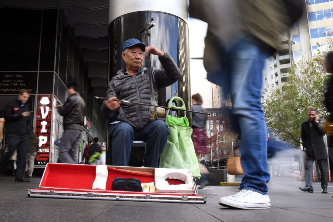 A busker plays a traditional Chinese fiddle, or "erhu", along a street in Sydney. For the first time Asian migration has outstripped European, and Mandarin is now the second-most spoken language after English. Photo: AFP