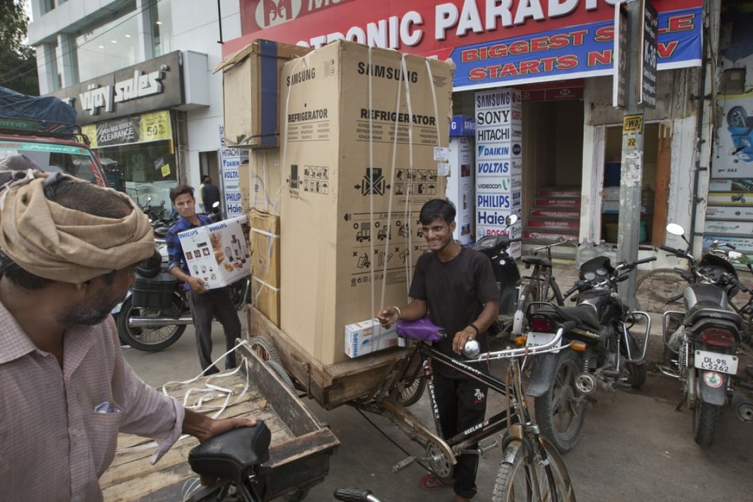 An Indian labourer in New Delhi loads a cart to be delivered ahead of the implementation of the Goods and Services Tax. Photo: AP