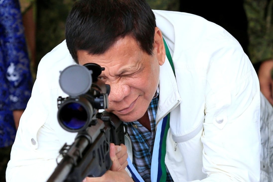Philippines President Rodrigo Duterte checks the scope of a 7.62mm sniper rifle during a turnover ceremony of China's military help given to the Philippines, at Clark Air Base on June 28. Photo: Reuters