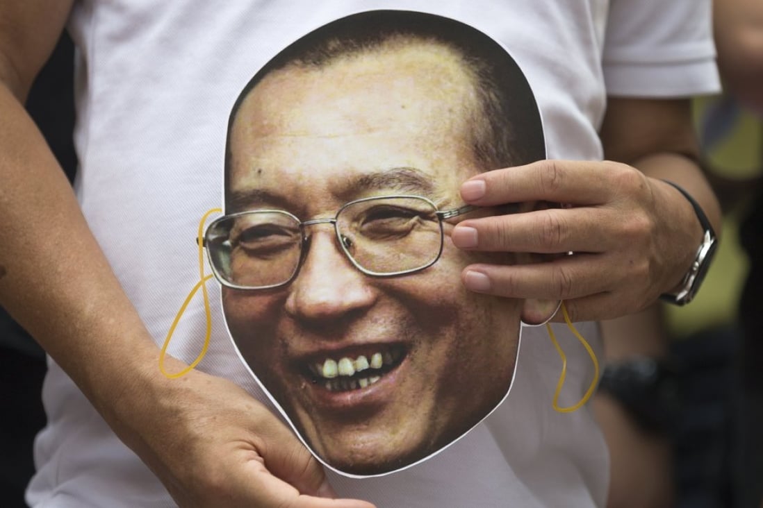 A protester holds a mask with the face of Chinese dissident and Nobel laureate Liu Xiaobo during a protest outside the central government’s liaison office in Hong Kong on June 27. Photo: EPA