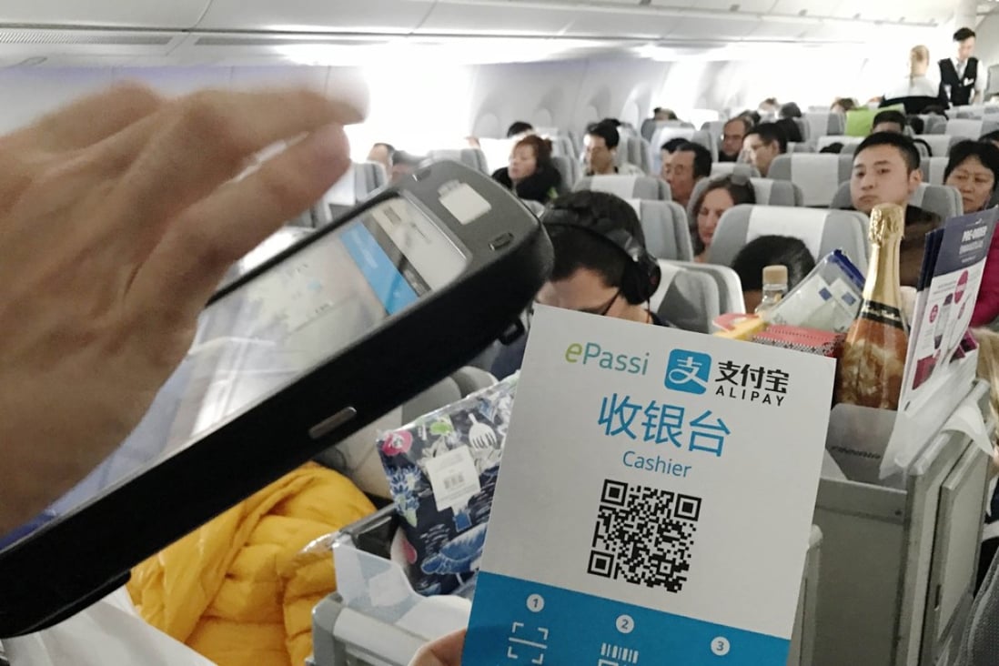 A flight attendant collects payment with Alipay on a flight bound for Helsinki from Beijing. Alipay joined hand with Finnish ePassi to start its business in Finland in January, 2017. Photo: AFP