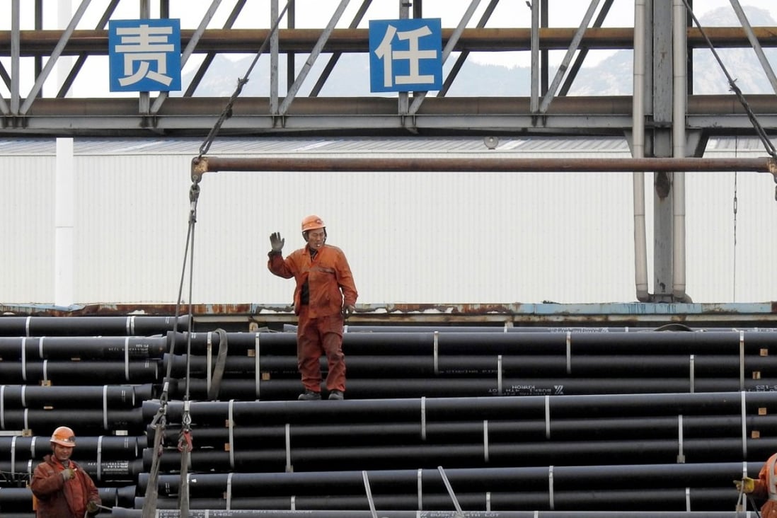 Chinese workers load steel tubes onto a truck at a logistics centre in Lianyungang in east China's Jiangsu province. Photo: AFP