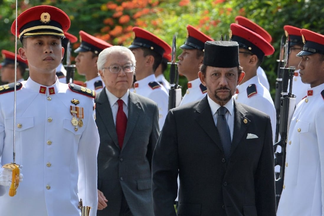 Sultan of Brunei Hassanal Bolkiah, front right, is accompanied by Singapore's President Tony Tan Keng Yam as they inspect an honour guard during his welcoming ceremony at the Istana presidential palace in Singapore. Photo: AFP