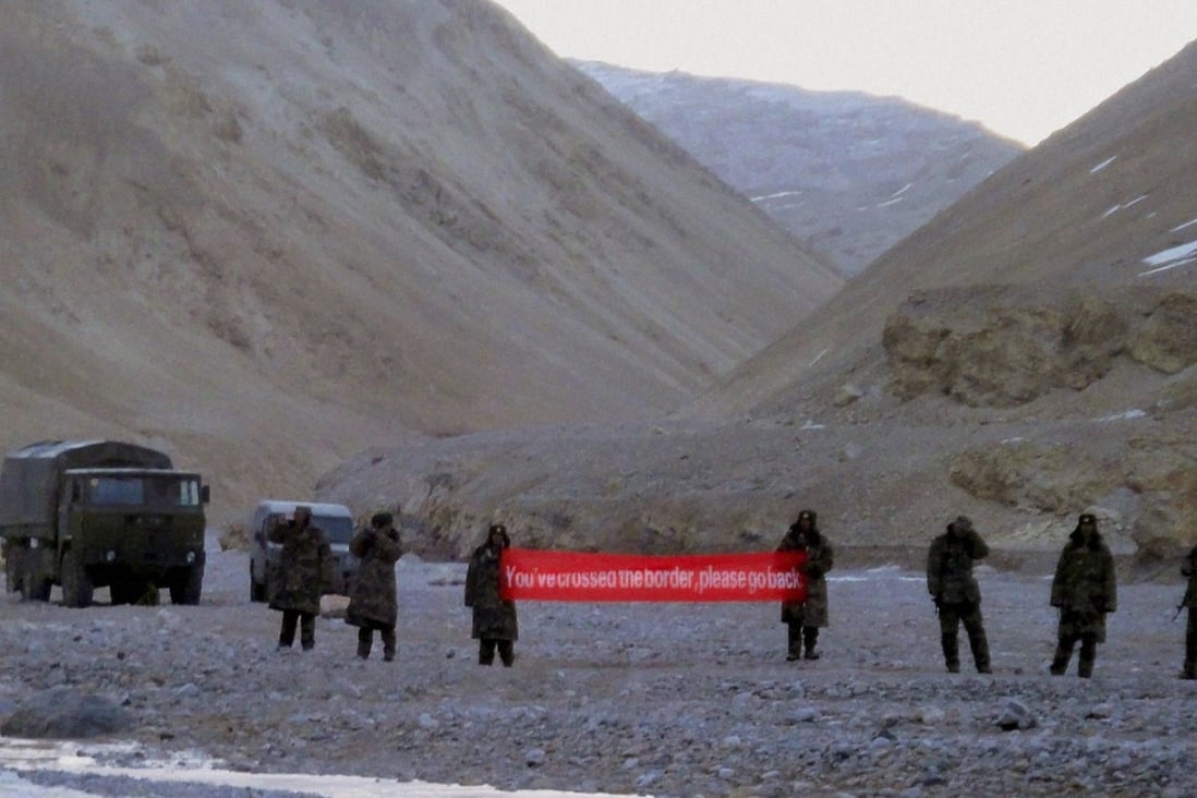 Chinese troops hold a banner which reads "You've crossed the border, please go back" in Ladakh, India. India has said it is ready to hold talks with China with both sides pulling back their forces to end a stand-off along a disputed territory high in the Himalayan mountains. Photo: Associated Press