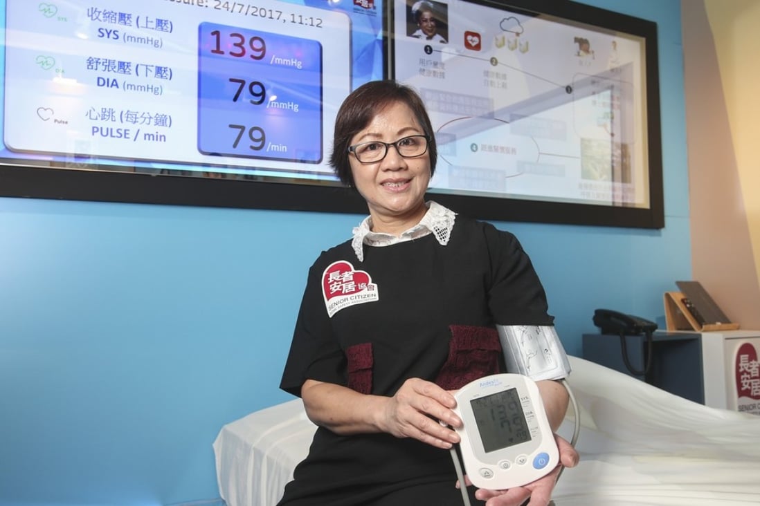 User Ho Yuk-ling demonstrates one of the devices at the show flat which can automatically upload blood pressure data. Photo: K. Y. Cheng