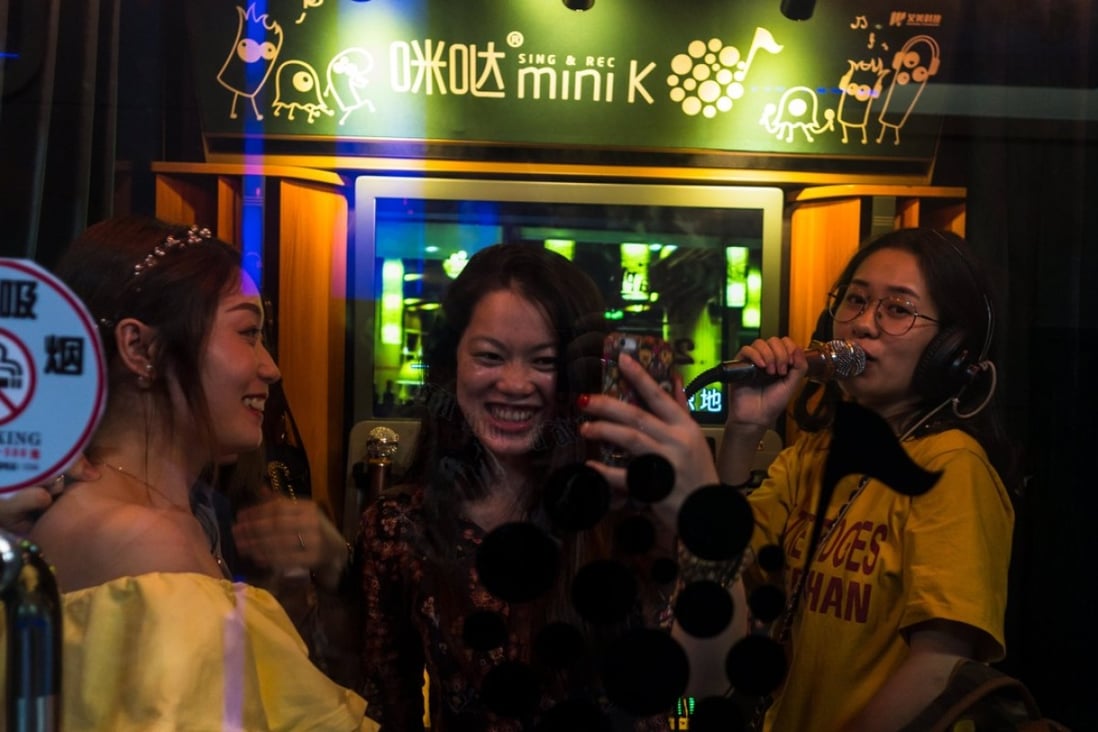 Three women enjoying a sing-song at a karaoke booth in Shenzhen. Photo: EPA
