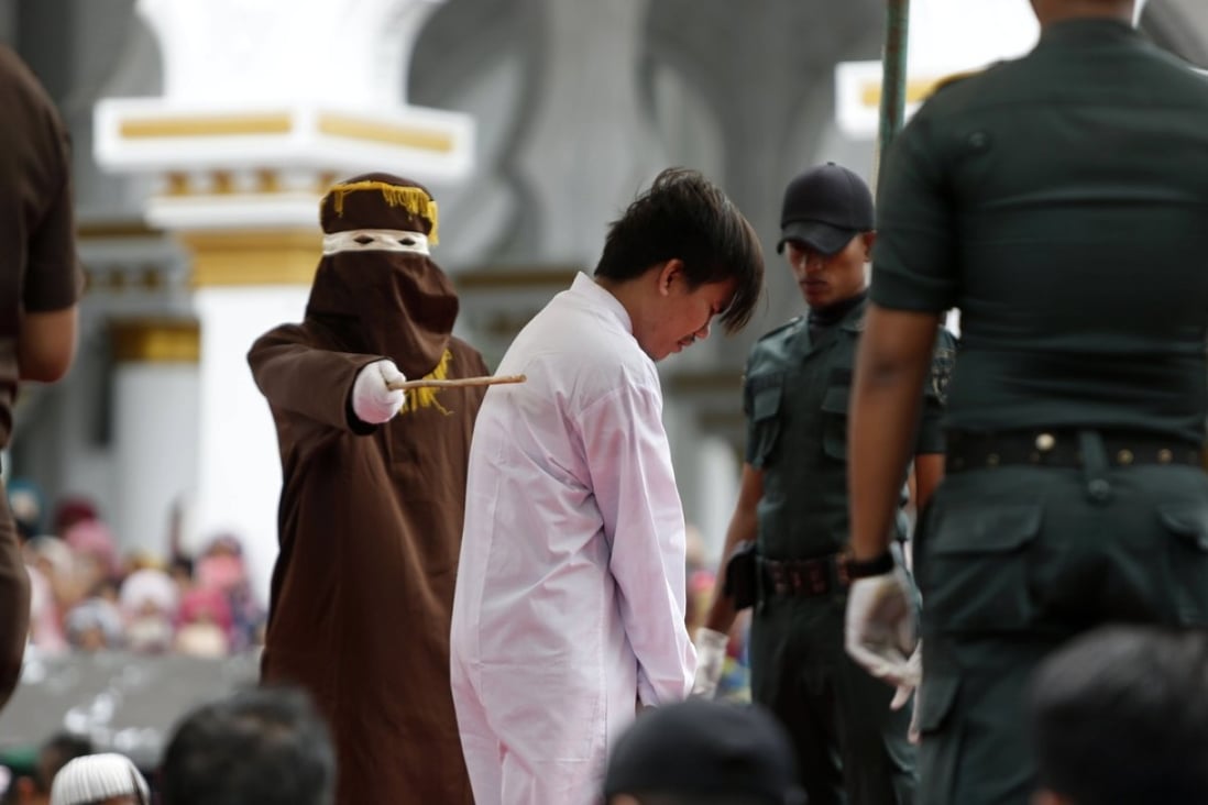A man is caned for being in a same-sex relationship in Banda Aceh, Indonesia. Fears of such reprisals are keeping many gay men away from necessary health services in the region. Photo: EPA