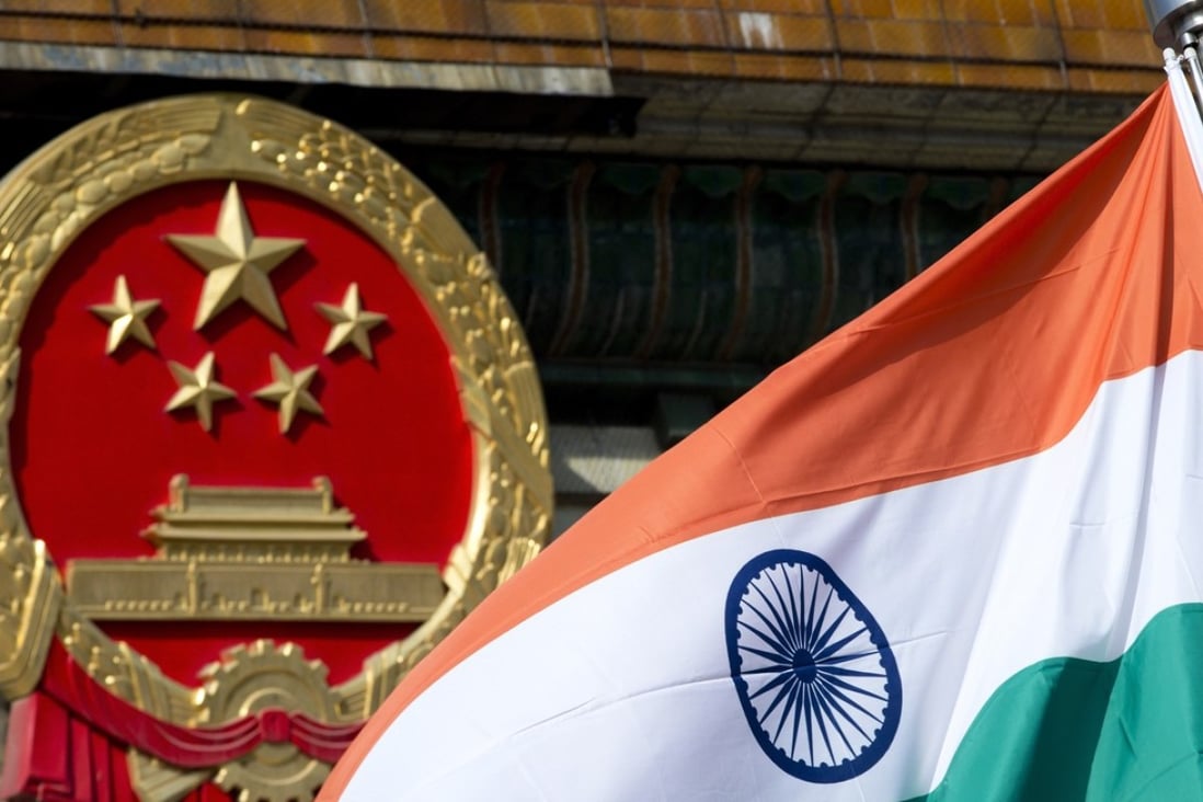 The Indian national flag flies next to the Chinese national emblem outside the Great Hall of the People in Beijing. The two nations could be on the brink of war. Photo: AP