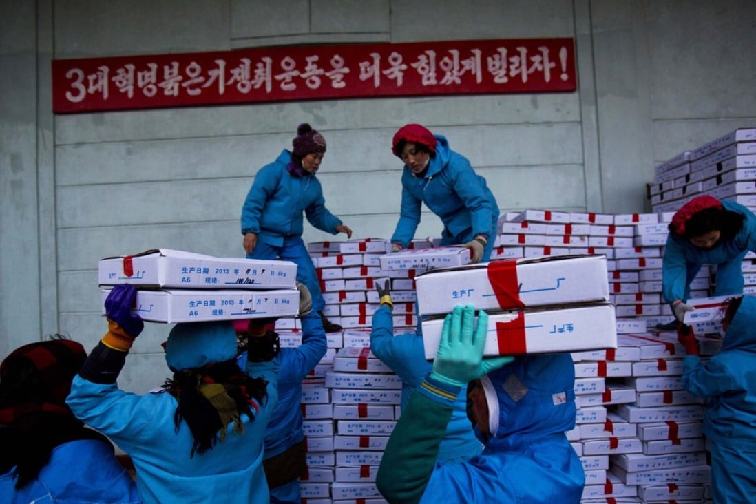 North Korean workers carry boxes of seafood as they load a Chinese transport truck at the Suchae Bong Corp seafood factory in Rajin, North Korea. Jessica Bartlett, a senior associate at Freshfields Bruckhaus Deringer based in Hong Kong. says since the vast amount of trade between the countries is conducted in dollars, that would make it near impossible for many Chinese banks to do business if sanctions get tougher.