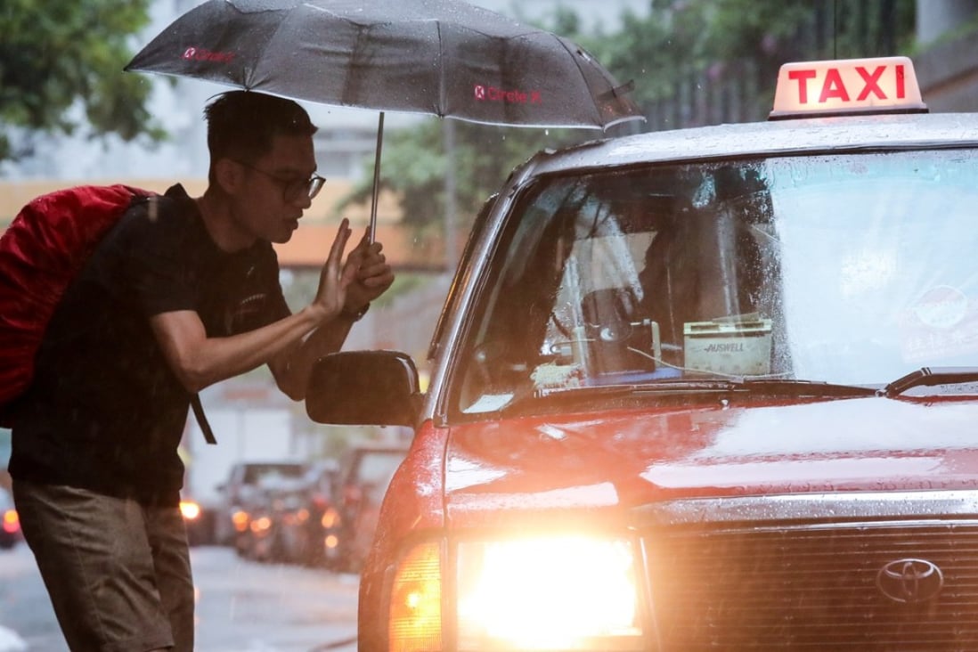 A passenger hails a cab in Hung Hom during a typhoon last year. Photo: Bruce Yan