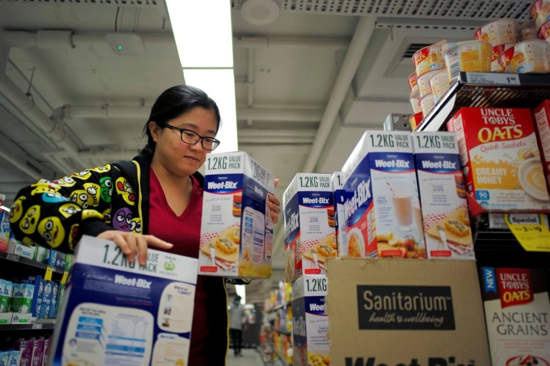 Chinese daigou shopping agent Na Wang selects an Australian breakfast cereal product during a shopping trip for Chinese customers at an Australian supermarket in Sydney. Photo: Reuters