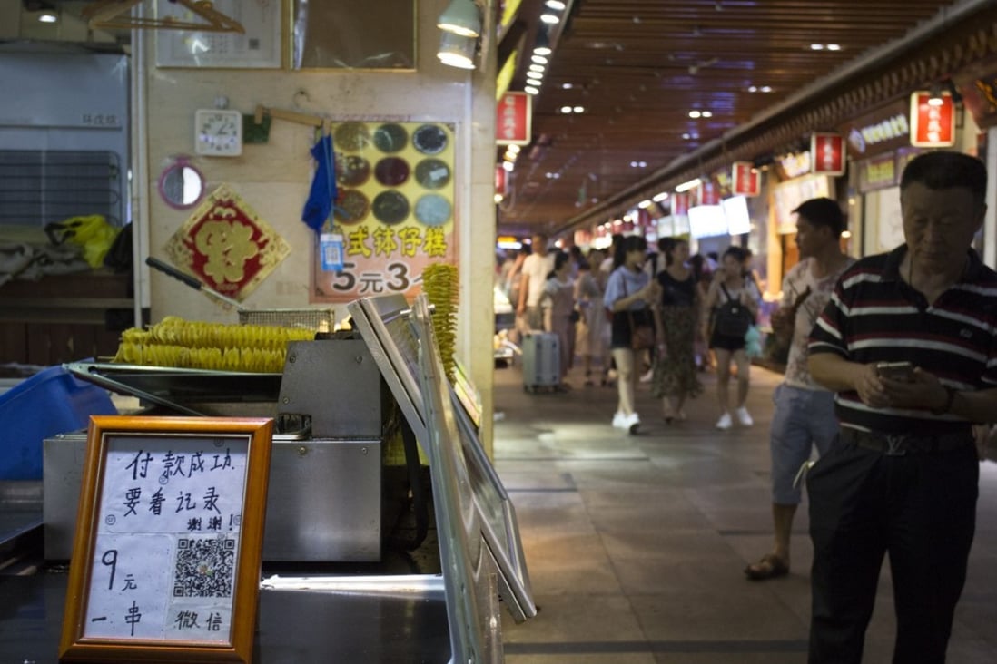 A stall in Shenzhen’s Dong Men Ding Plaza displays a QR code for mobile payment. Photo: May Tse