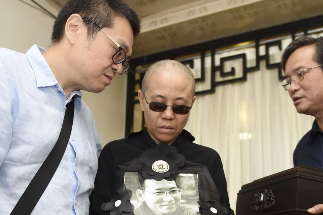 Liu Xia (centre), wife of late Nobel Peace Prize winner Liu Xiaobo, holds a portrait of her husband during his funeral in Shenyang in July. Supporters said they contacted her on Saturday. Photo: AP