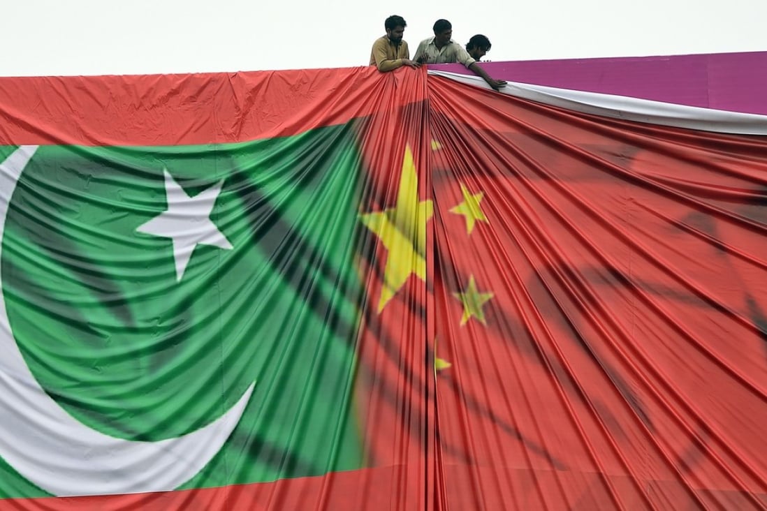 Workers arrange a banner featuring the Chinese and Pakistani flags ahead of a visit to Islamabad by China’s President Xi Jinping in 2015. Pakistan’s Foreign Minister Khawaja Asif is expected to arrive in Beijing on Friday. Photo: AFP