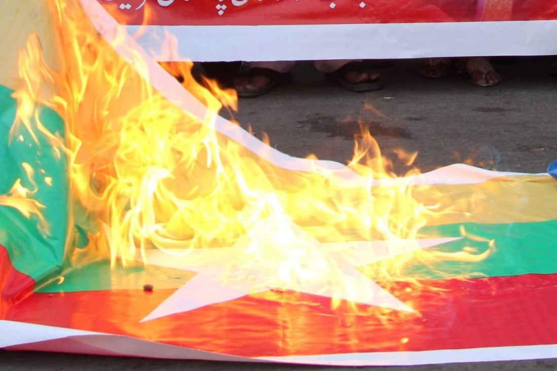 A Myanmar flag is torched in Pakistan during a protest in support of Rohingya Muslims. Photo: AFP
