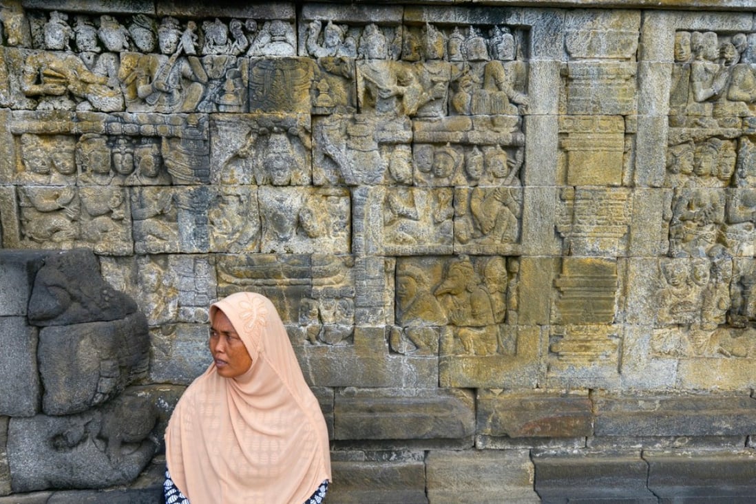 A woman visits the Buddhist temple of Borobudur. Photo: Alamy