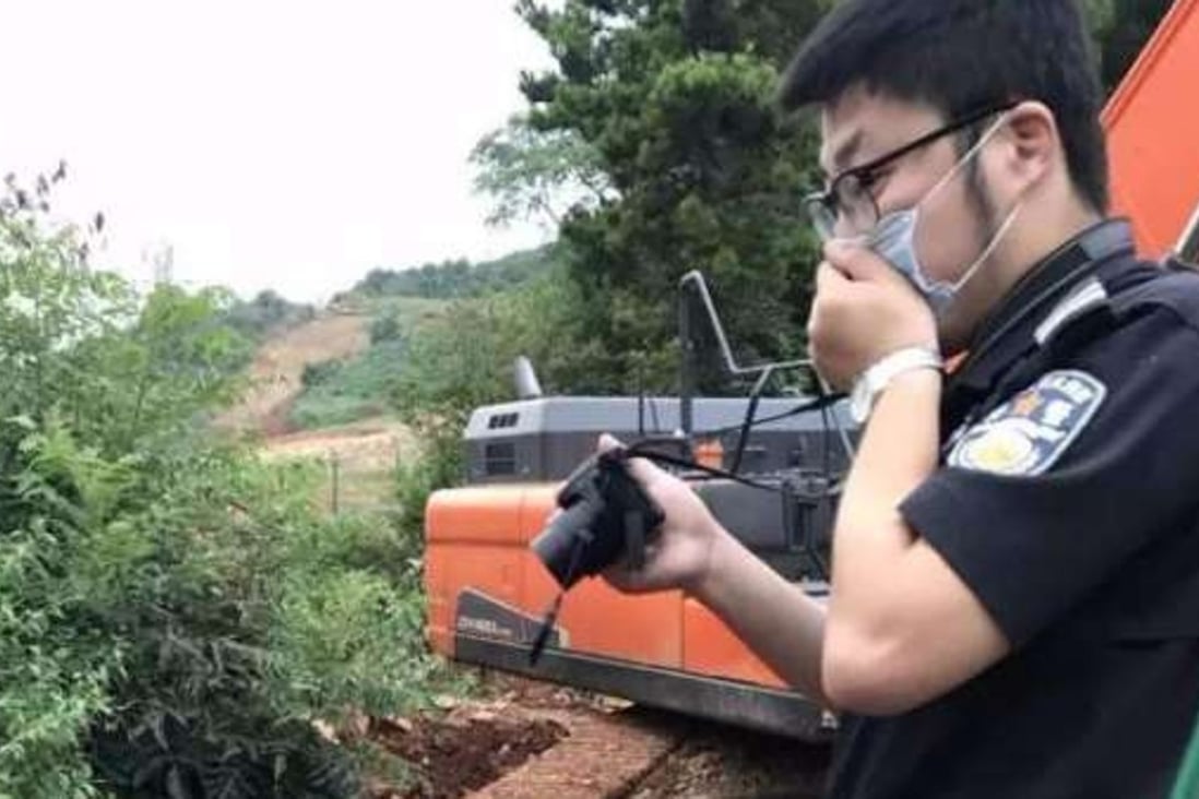 An inspector covers his mouth at the site where 300 tonnes of rotting pig were uncovered in Zhejiang province. Photo: Handout